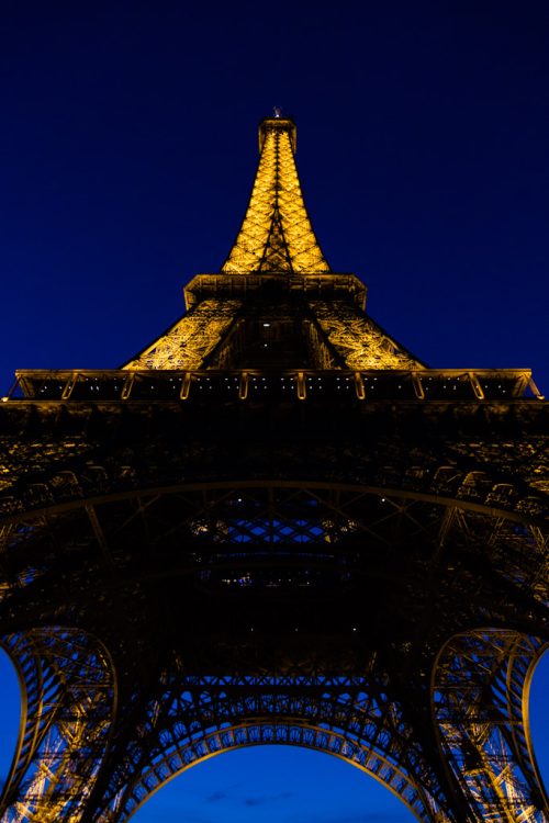 Illuminated base of Eiffel Tower in Paris, France at night