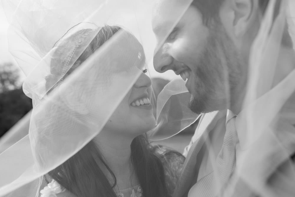 bride and groom under veil