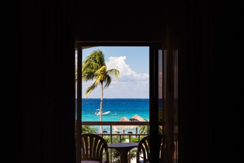 Ocean view with palm tree from resort window at Cozumel Mexico destination wedding