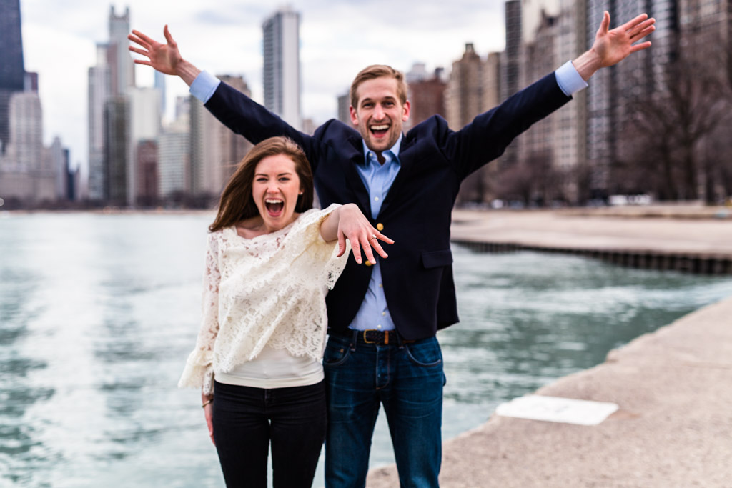 Chicago lakefront proposal photo of couple cheering at North Avenue Beach