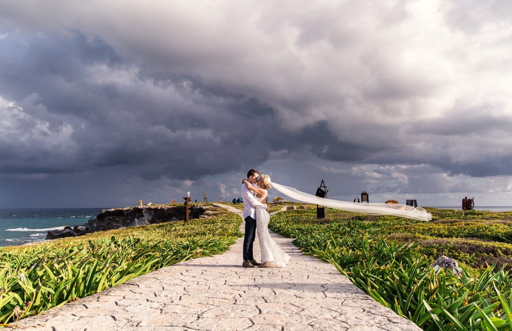 Isla Mujeres destination wedding portrait of bride and groom with veil and stormy sky