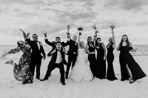 Fun wedding party photo cheering on beach at Cancun destination wedding