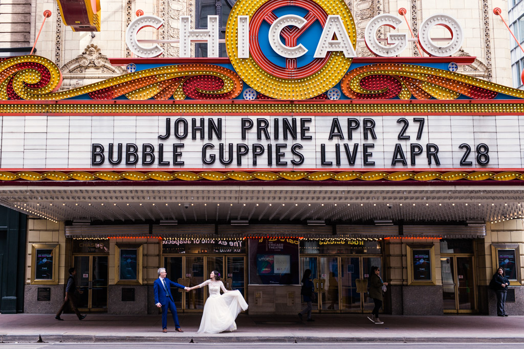 Bride and groom in front of Chicago Theatre after their downtown Chicago elopement