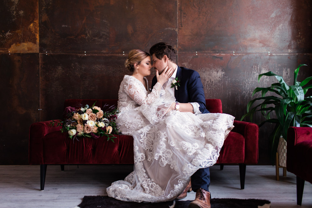 bride and groom on velvet couch at Ogden, Utah wedding venue The 5th Floor