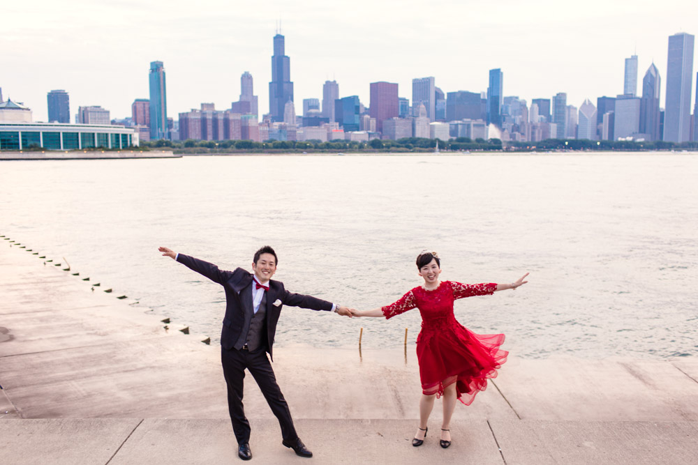 Couple travels from Japan for Chicago destination wedding photo with skyline at Adler Planetarium