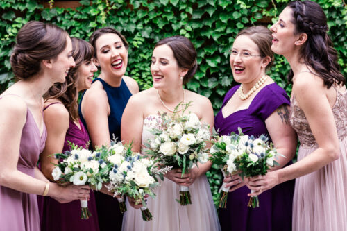 Candid photo of Chicago bride and bridesmaids with ivy wall at The Joinery Chicago wedding