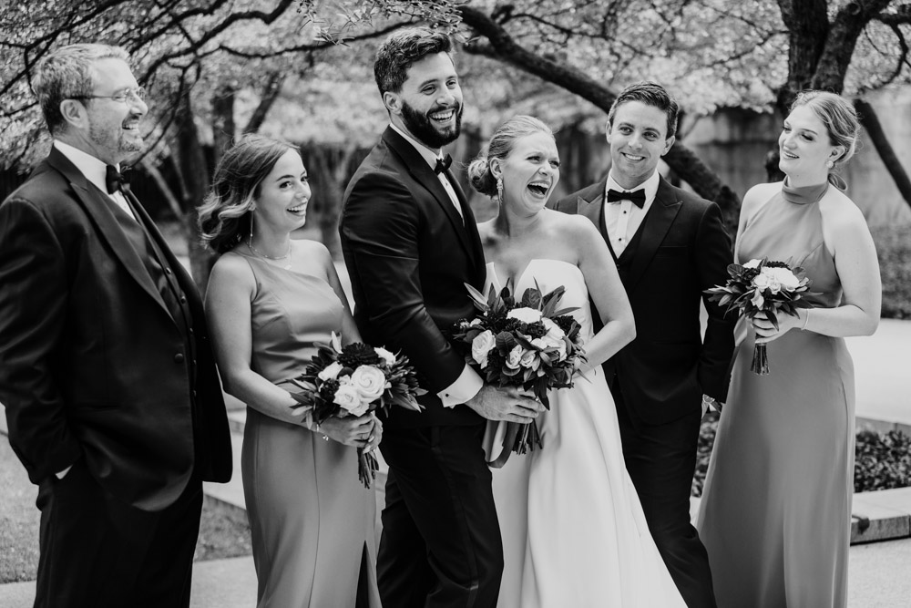 Candid photo of wedding party laughing at Art Institute Garden before Chicago Athletic Association wedding