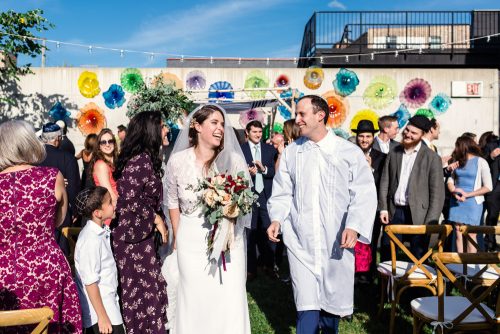 Happy bride and groom exit their Chicago Ignite Glass Studio wedding ceremony