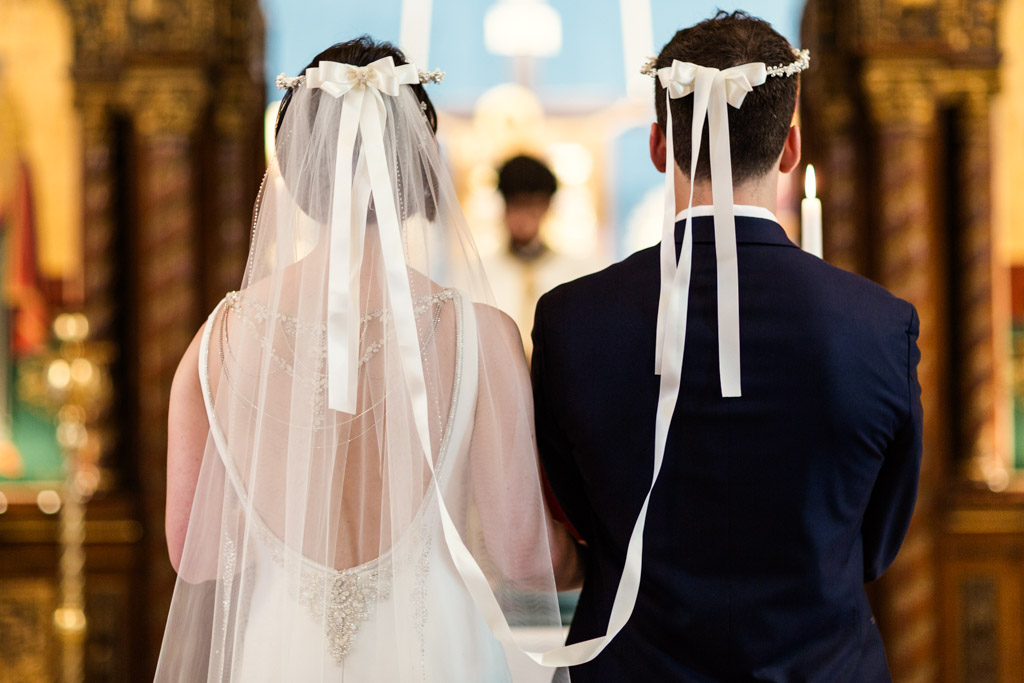 Bride and groom wear crowns during Greek Orthodox wedding ceremony at St. George in Lincoln Park, Chicago