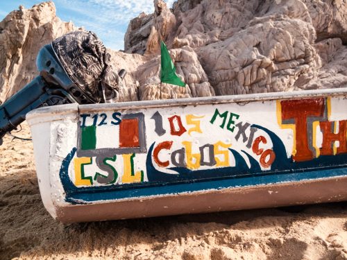 Painted boat on Lovers Beach in Cabo San Lucas, Mexico by travel photographer Emma Mullins Photography