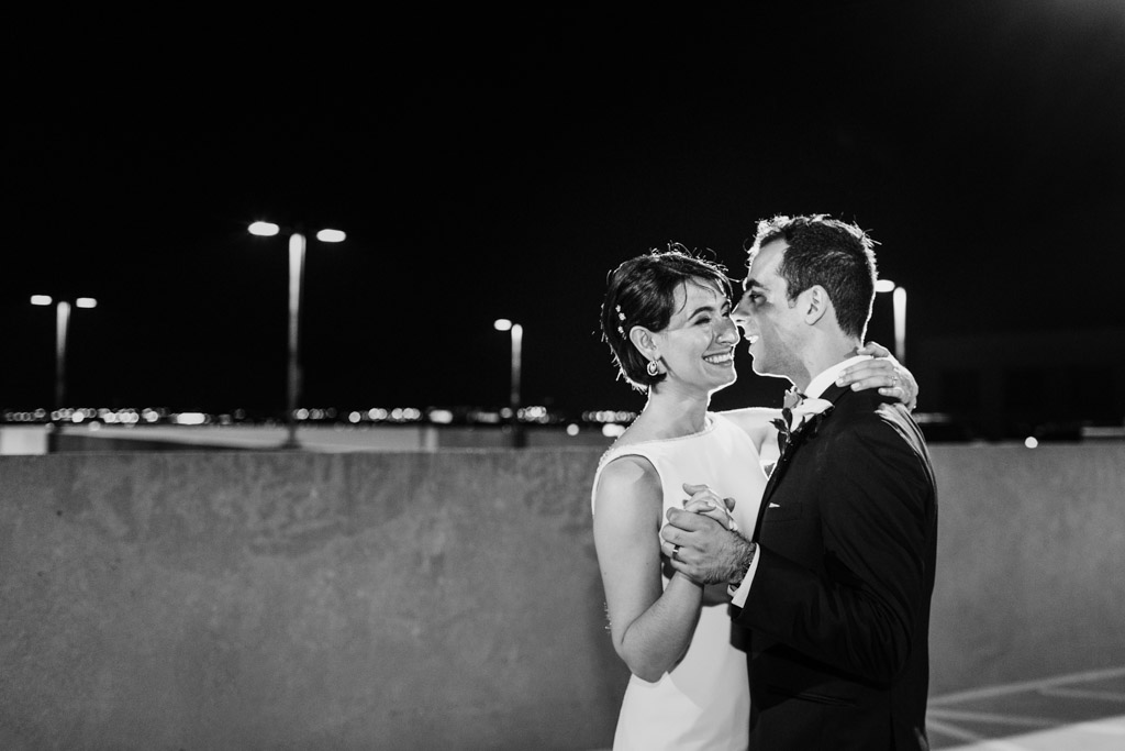 Romantic night photo of bride and groom dancing on rooftop parking garage at their Loews Chicago wedding