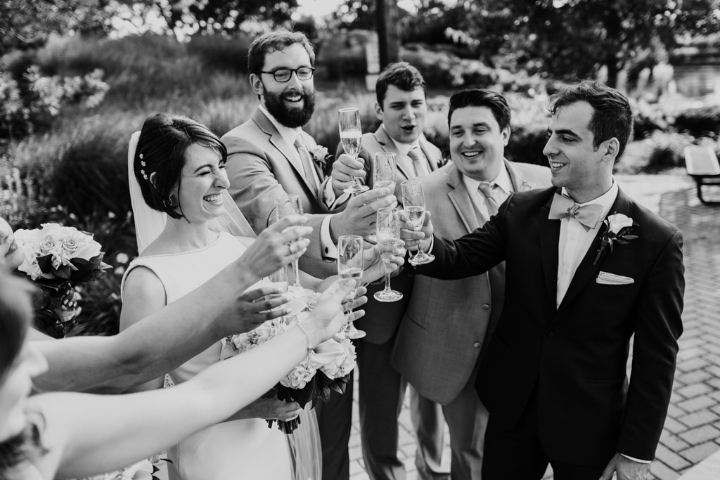 Candid photo of Chicago wedding party toasting champagne in park