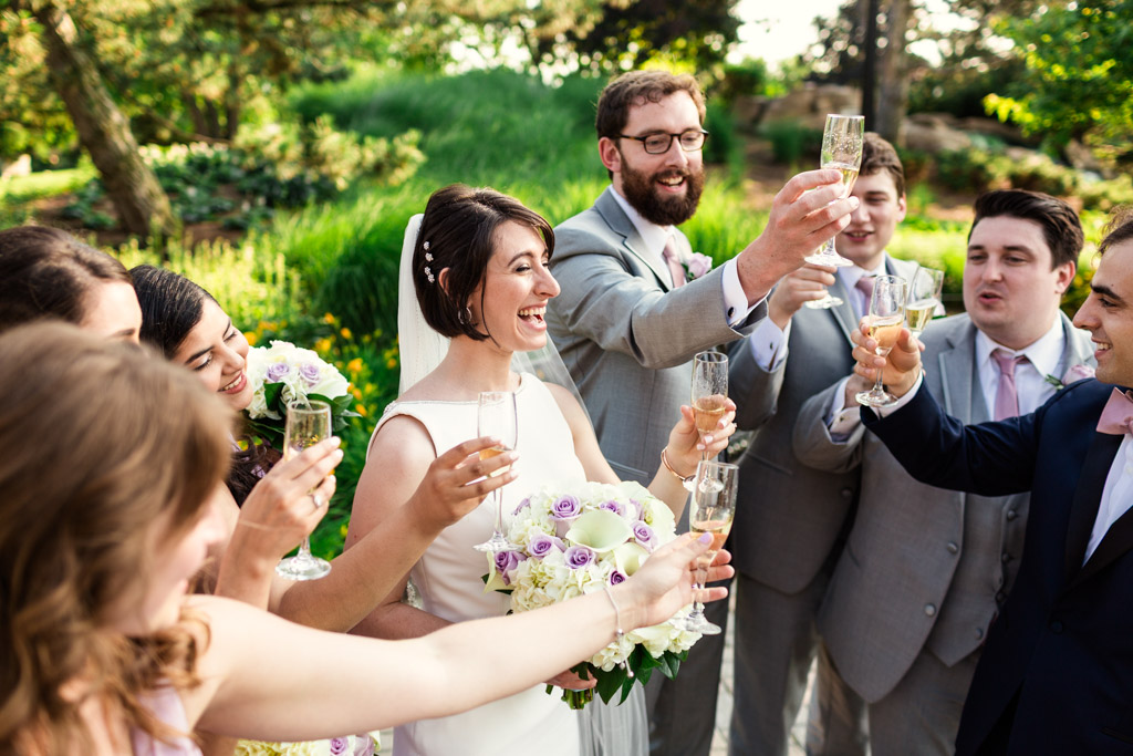 Wedding party toasts champagne in park before Loews Chicago wedding reception