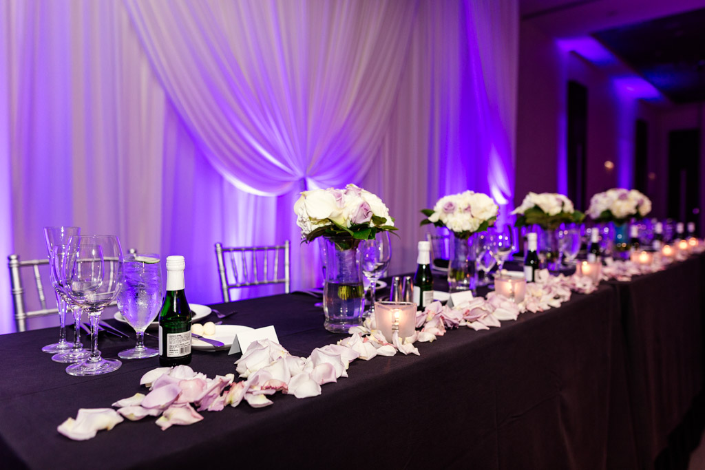 Loews Chicago wedding reception head table decor with rose petals and champagne