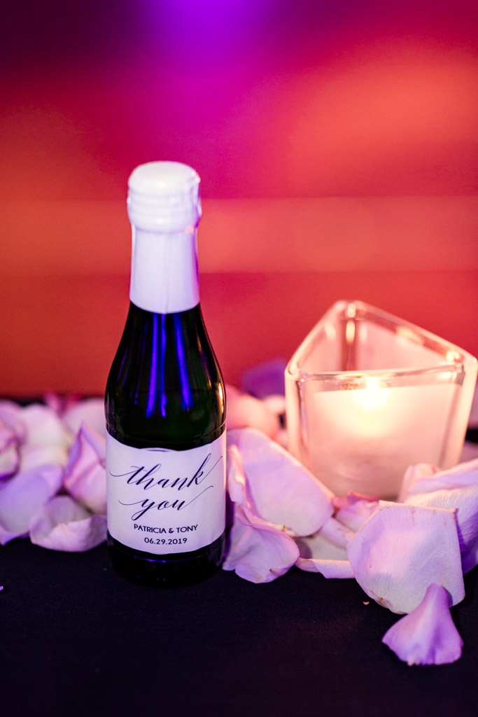 Mini champagne bottle guest favors on table at Loews Chicago wedding reception