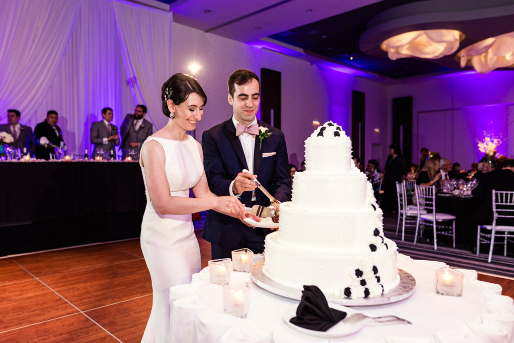 Bride and groom cut four-tier wedding cake at their Loews Chicago wedding reception