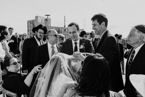 Groom greets bride during rooftop Bedeken ceremony at Ignite Glass Studios wedding