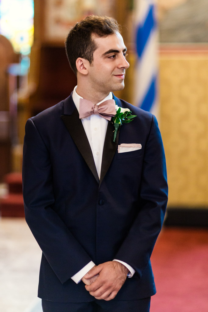 Groom watches bride walk down aisle at Chicago Greek Orthodox wedding ceremony at St. George