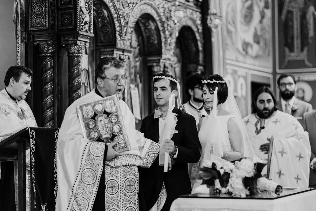 Bride and groom walk seven circles with Priests during Chicago Greek Orthodox wedding ceremony