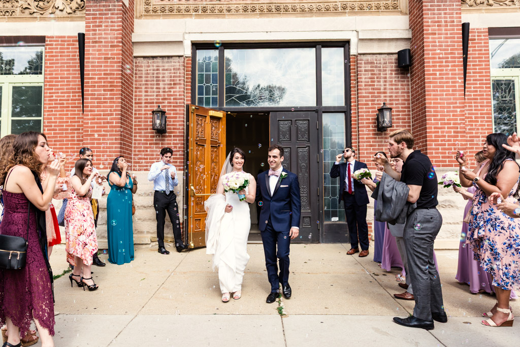Bride and groom's bubble exit after Chicago Greek Orthodox wedding ceremony at St. George in Lincoln Park