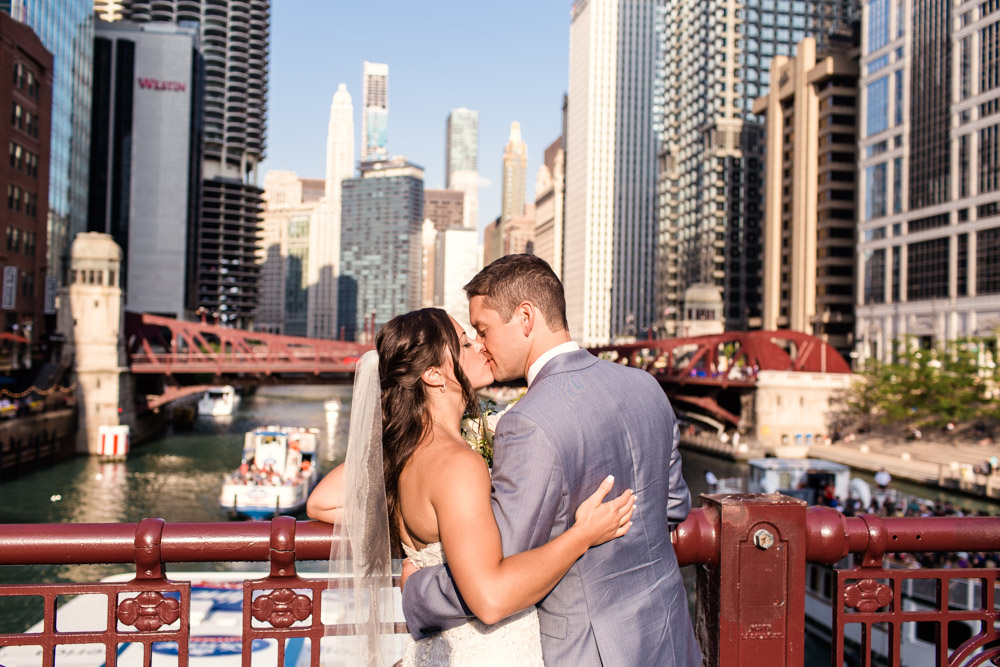 Chicago bride and groom kiss on LaSalle Bridge outside their summer River Roast wedding