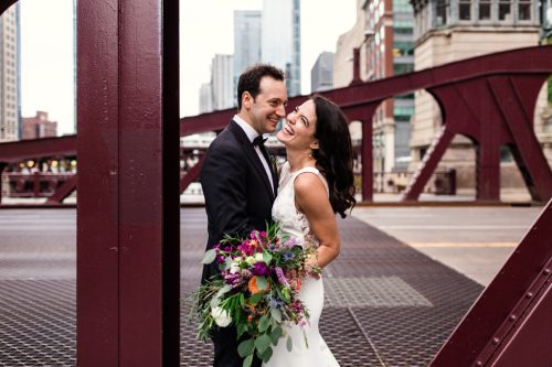 Candid photo of bride and groom laughing on bridge before their Chicago microwedding ceremony