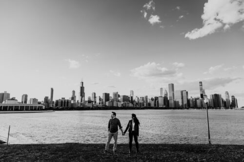 Moody engagement photo with Chicago skyline and lakefront outside Adler Planetarium