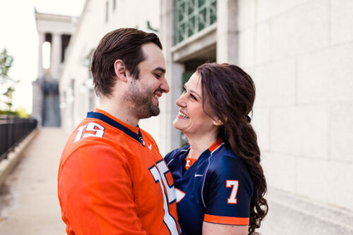 Candid Soldier Field engagement photo at stadium with orange and blue football jerseys