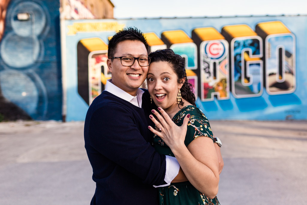 Couple shows off engagement ring in front of colorful Chicago mural