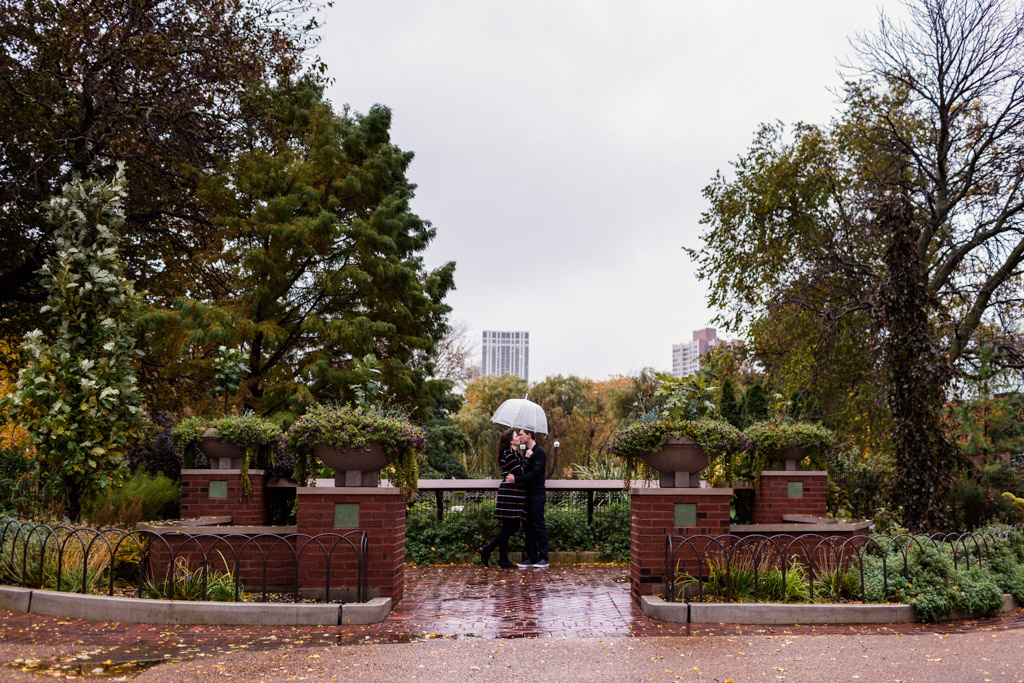 Romantic Lincoln Park Zoo engagement photo of couple under umbrella in the rain