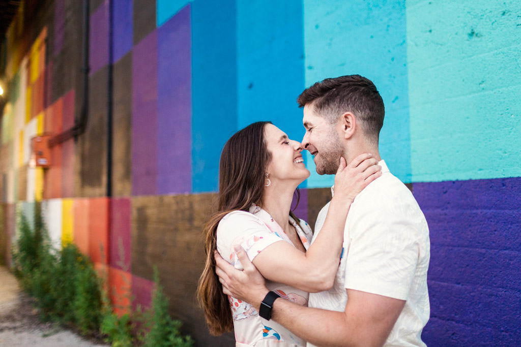 West Loop engagement photo of couple smiling in front of colorful wall