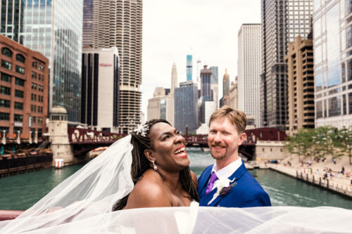 Chicago Riverwalk wedding photo of bride and groom smiling with veil in the wind