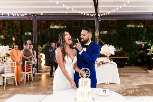 Fun photo of groom feeding bride wedding cake at Galleria Marchetti wedding reception