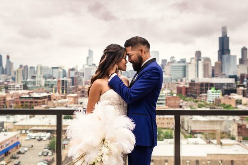 Romantic photo of bride and groom on rooftop with Chicago skyline and stormy skies