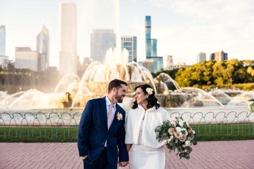 Buckingham Fountain wedding photo of happy bride and groom holding hands