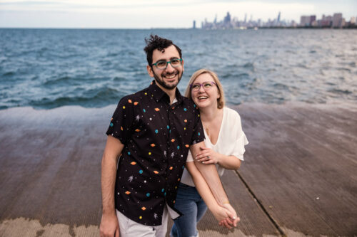 Candid photo of couple wearing space themed attire at Montrose Harbor during Lincoln Square engagement session