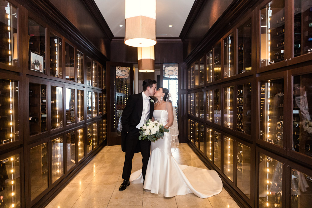 Bride and groom share a kiss in wine cellar at Mid-America Club wedding in Chicago