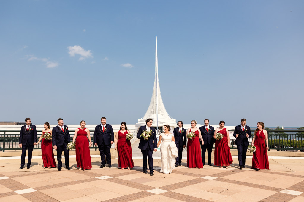 Candid photo of Wisconsin wedding party walking outside of Milwaukee Art Museum for summer lakefront wedding