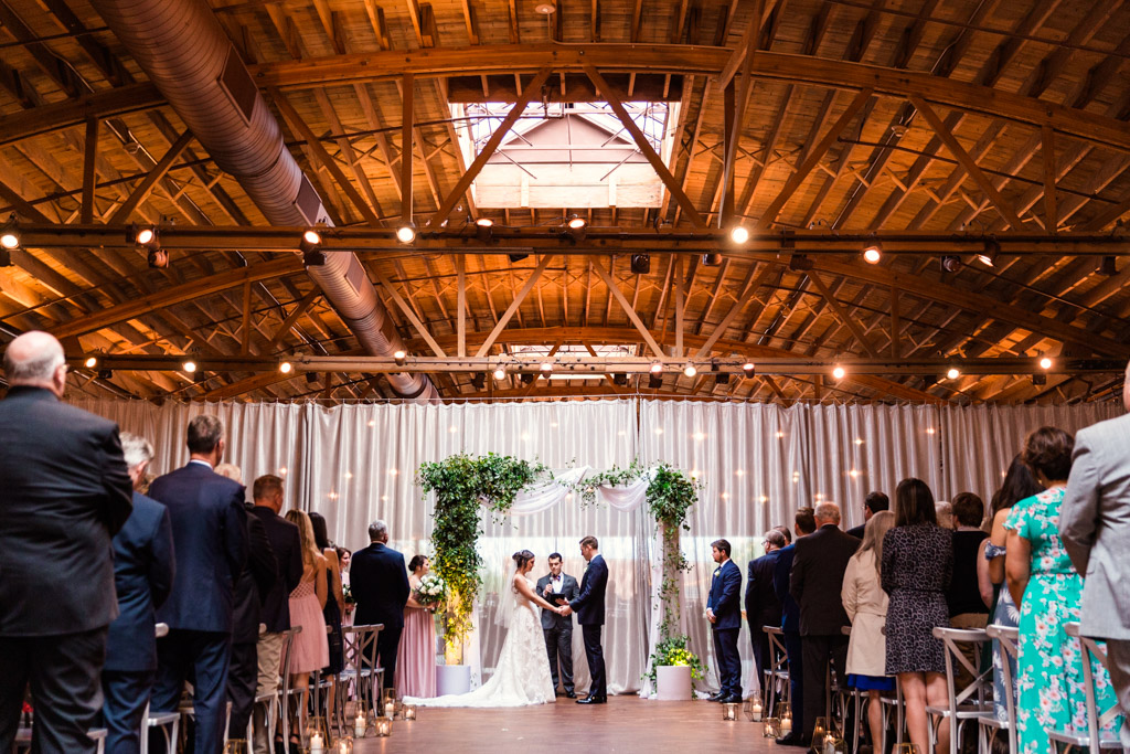 Romantic wedding ceremony under skylight at Chicago loft venue Rockwell on the River