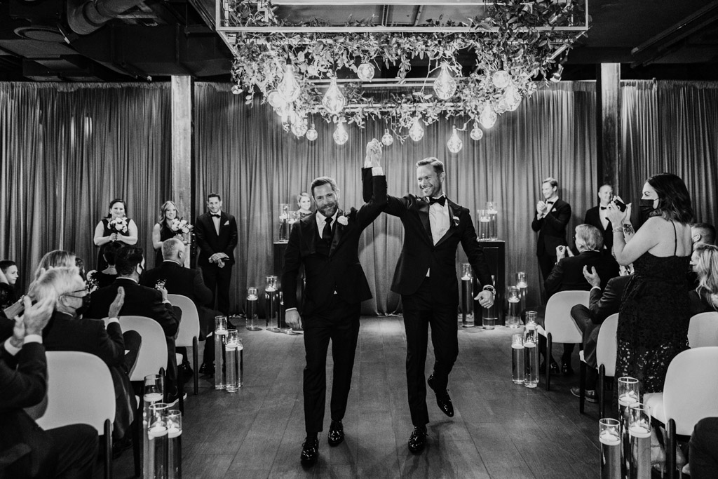 Just married grooms walk down the aisle after wedding ceremony at The Dalcy Chicago