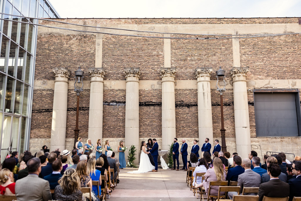 Artifact Events wedding ceremony in south courtyard with columns and greenery