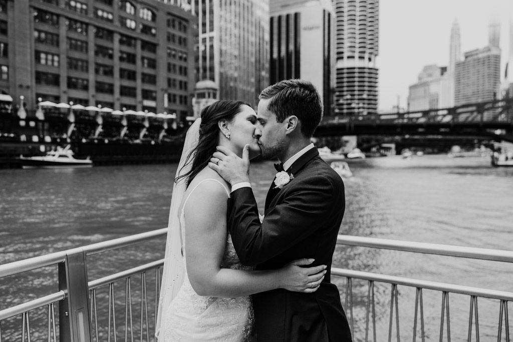 Romantic photo of bride and groom kissing on Riverwalk before Chicago library wedding reception at 190 S. LaSalle