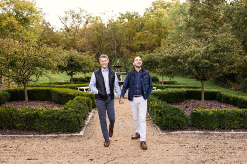Candid photo of couple holding hands while walking through garden at Wisconsin wedding venue