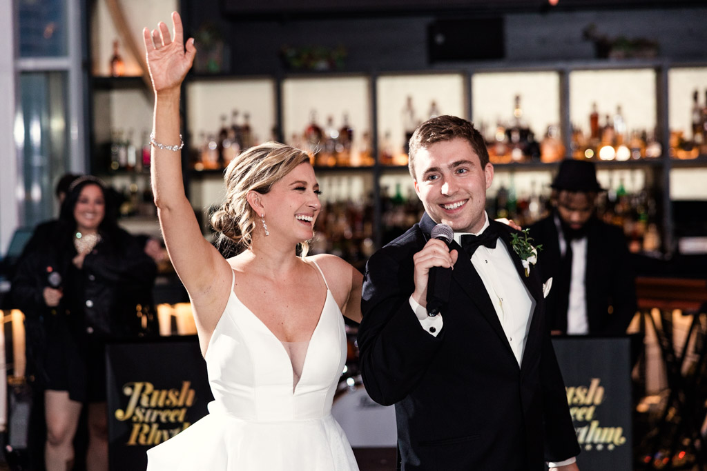 A smiling bride and groom celebrate on a dance floor at their ROOF on TheWit Chicago wedding reception