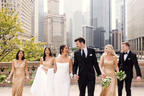 Candid photo of wedding party walking in front of Wrigley Building before Royal Sonesta Chicago Downtown wedding