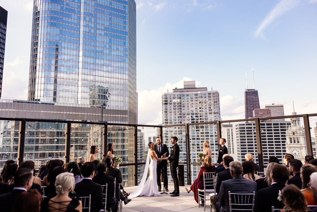 Bride and groom laugh during Royal Sonesta Downtown Chicago wedding ceremony on rooftop terrace