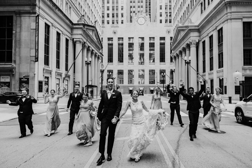 Candid photo of wedding party walking in front of Chicago Board of Trade downtown before September wedding reception