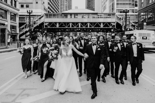 Fun photo of wedding party walking in State Street before downtown Chicago wedding at ROOF on theWit