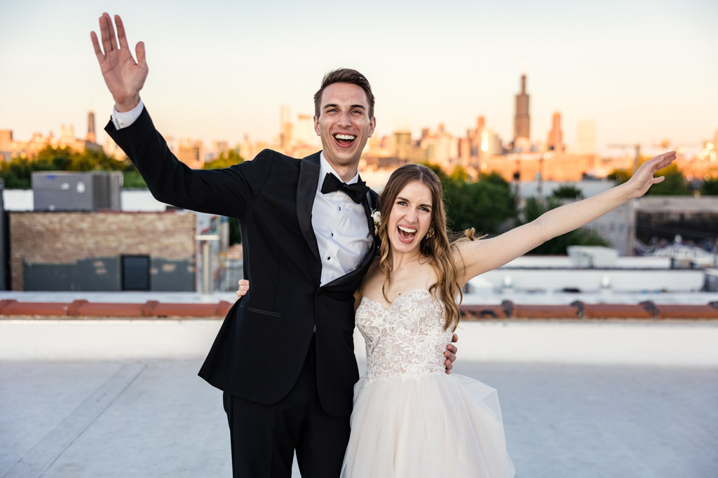 Fun photo of bride and groom celebrating on rooftop of Walden Chicago with skyline view