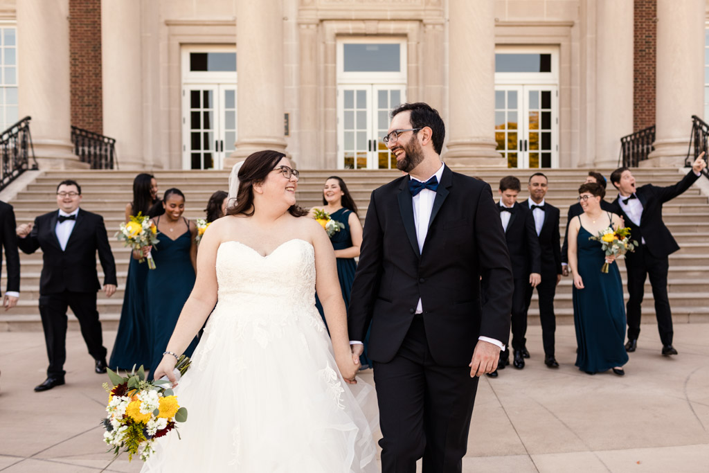 Fun photo of bride and groom walking with wedding party outside their Chicago History Museum wedding